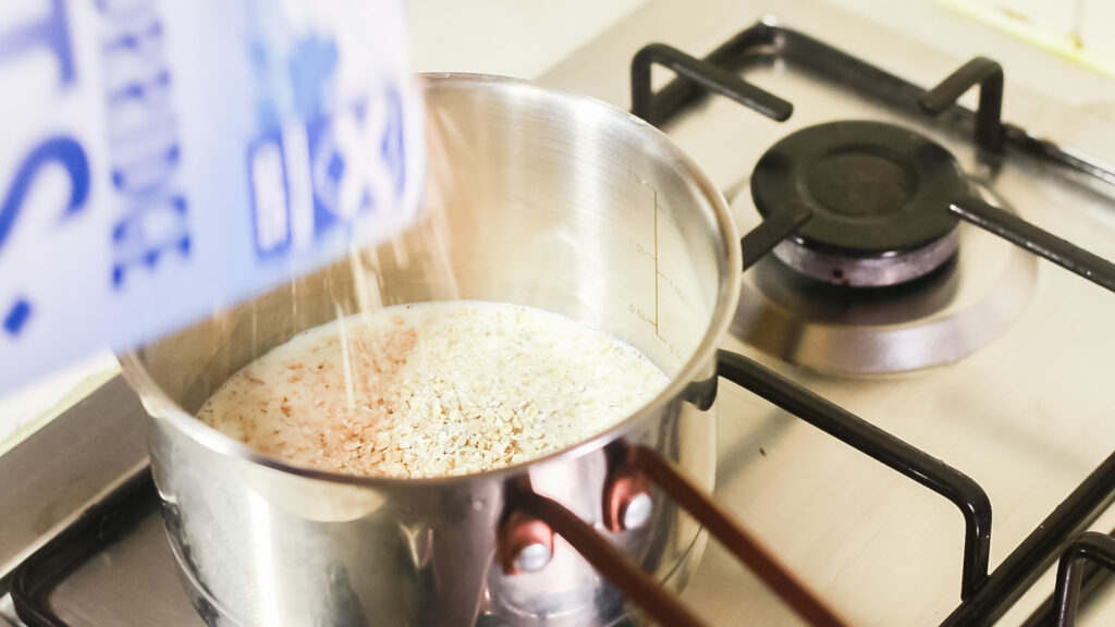 Pouring scottish porridge oats into a pot of milk