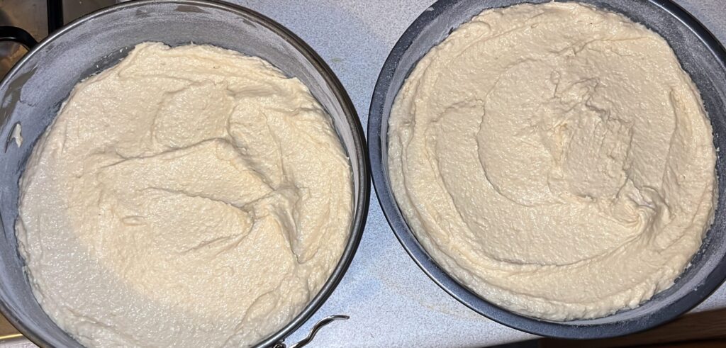 Victoria sponge cake batter poured into cake tins