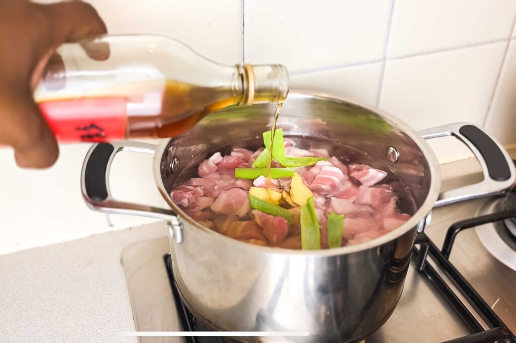 Pot of pork belly with slices of ginger and spring onions