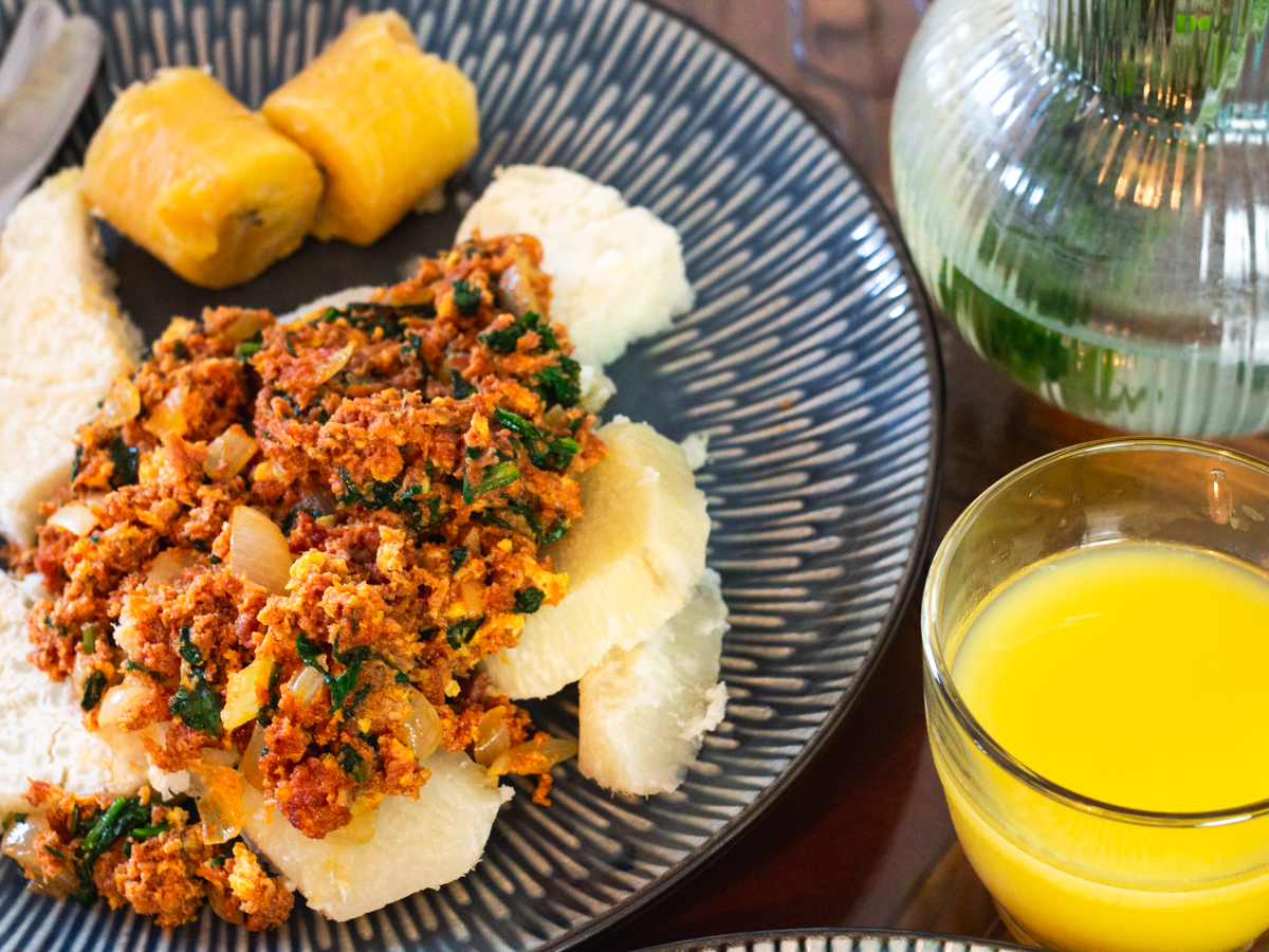 yam and egg corned beef stew with boiled plantain and a glass of orange juice