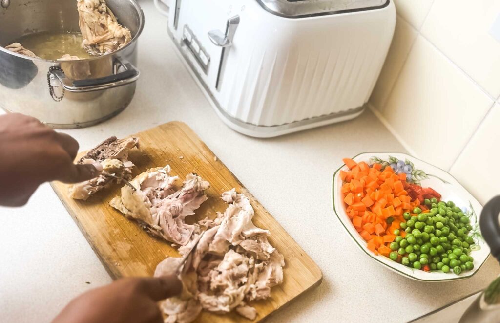 Shredding chicken for nigerian coconut rice