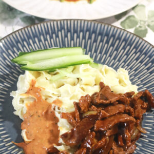 Onion beef stir fry with burdock root noodles, sesame sauce and sliced cucumbers