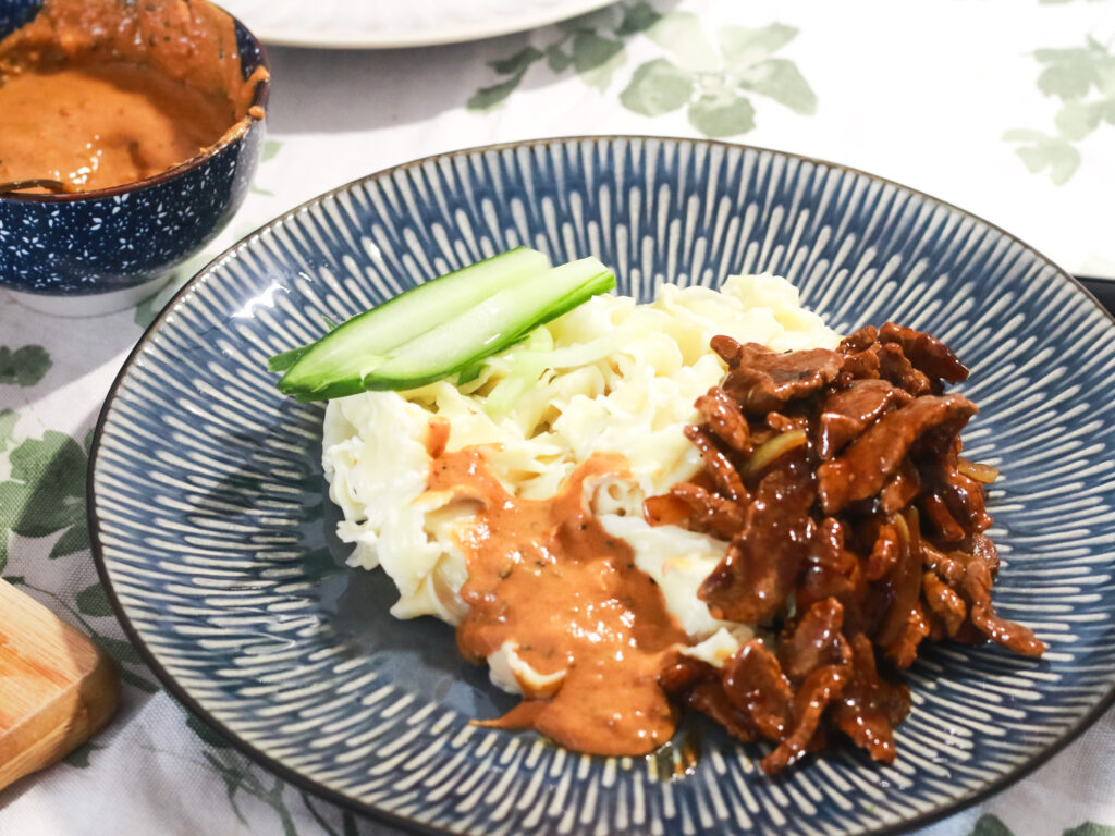 Onion beef stir fry with burdock root noodles, sesame sauce and sliced cucumbers