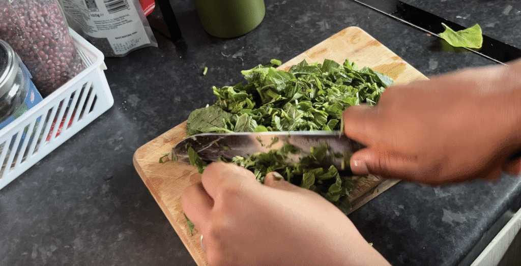 Chopping callaloo/ african spinach for efo riro