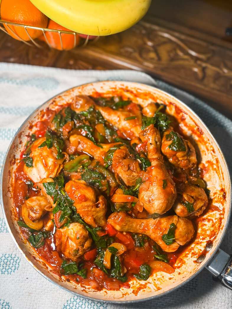 Chicken stir fry with bell peppers and spinach in frying pan